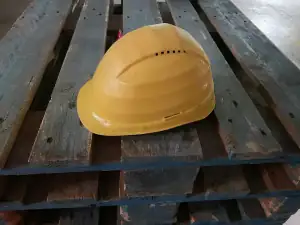 Yellow hard hat resting on a pallet