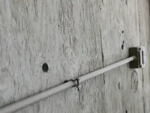 Pipe fixed to a wall with a clamp