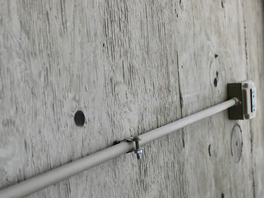 Pipe fixed to a wall with a clamp